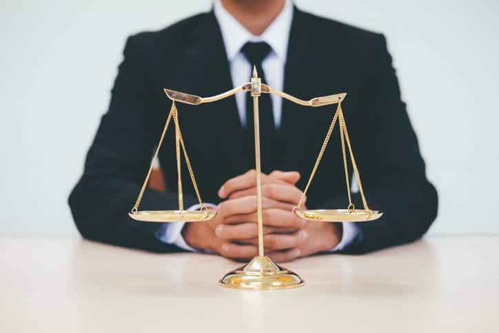 A slip-and-fall injury attorney sits behind the scales of justice. 