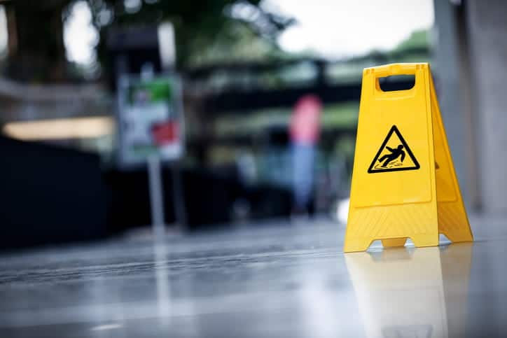 A yellow caution sign on a sidewalk.